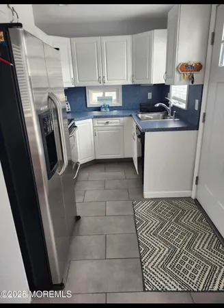 a kitchen with a sink a stove a refrigerator and cabinets