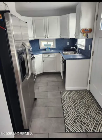 a kitchen with a sink a stove a refrigerator and cabinets