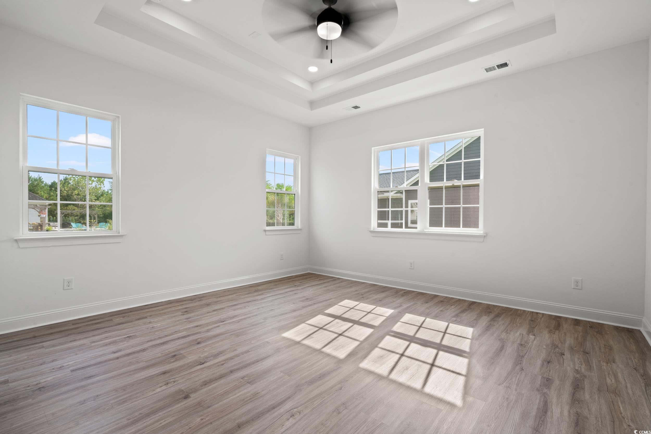 1009 Englemann Oak Drive Myrtle Beach, SC 29579 - Photo 13 of 38 Spare room with light wood-style floors, a ceiling fan, a tray ceiling, and recessed lighting