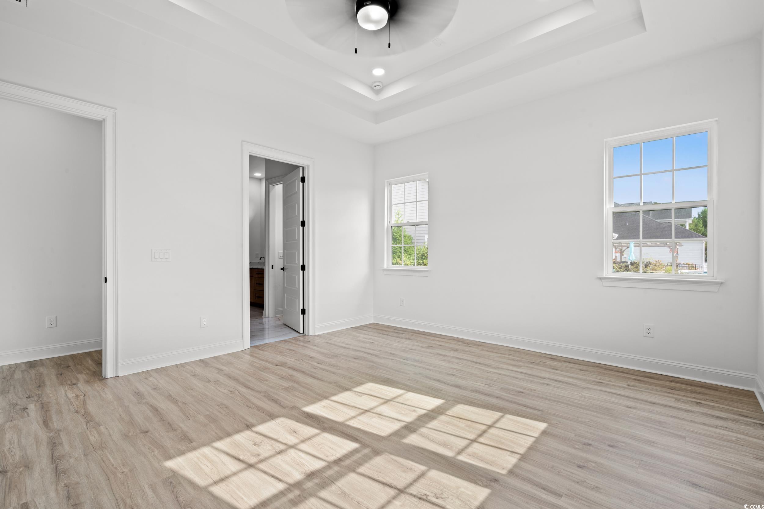 1009 Englemann Oak Drive Myrtle Beach, SC 29579 - Photo 15 of 38 Unfurnished bedroom featuring light wood-type flooring, ceiling fan, and a tray ceiling