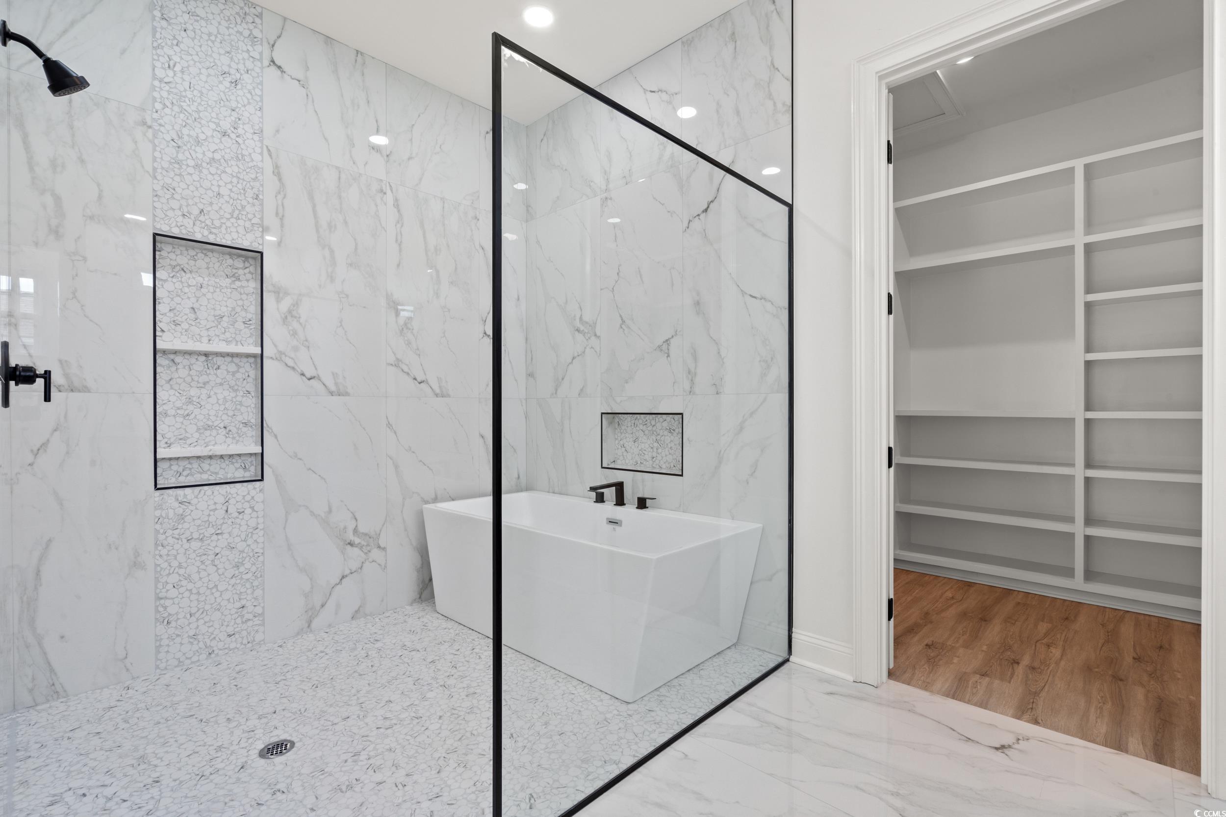 1009 Englemann Oak Drive Myrtle Beach, SC 29579 - Photo 17 of 38 Full bath with marble tiled flooring, a spacious closet, a marble finish shower, a soaking tub, and tile walls