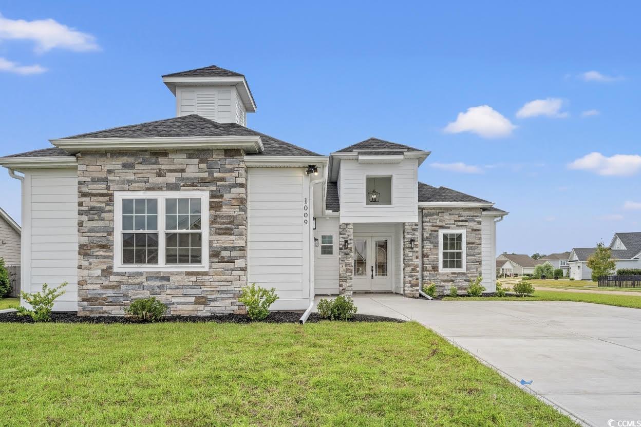1009 Englemann Oak Drive Myrtle Beach, SC 29579 - Photo 2 of 38 View of front of home featuring stone siding, a front yard, and a shingled roof
