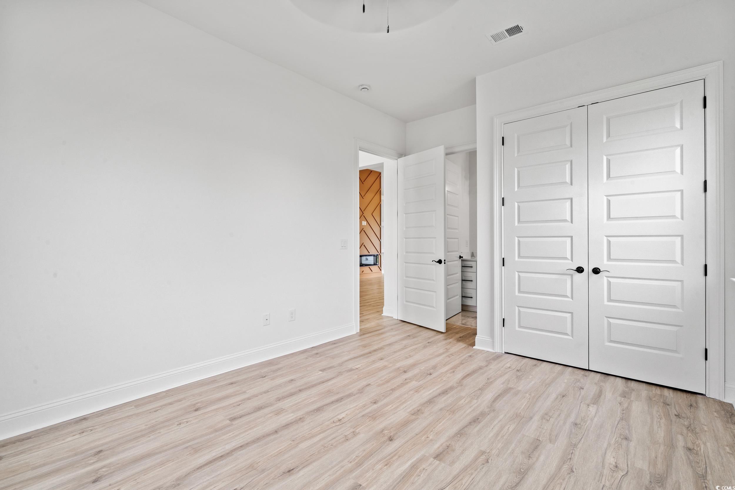 1009 Englemann Oak Drive Myrtle Beach, SC 29579 - Photo 23 of 38 Unfurnished bedroom with light wood-type flooring, a closet, and a ceiling fan