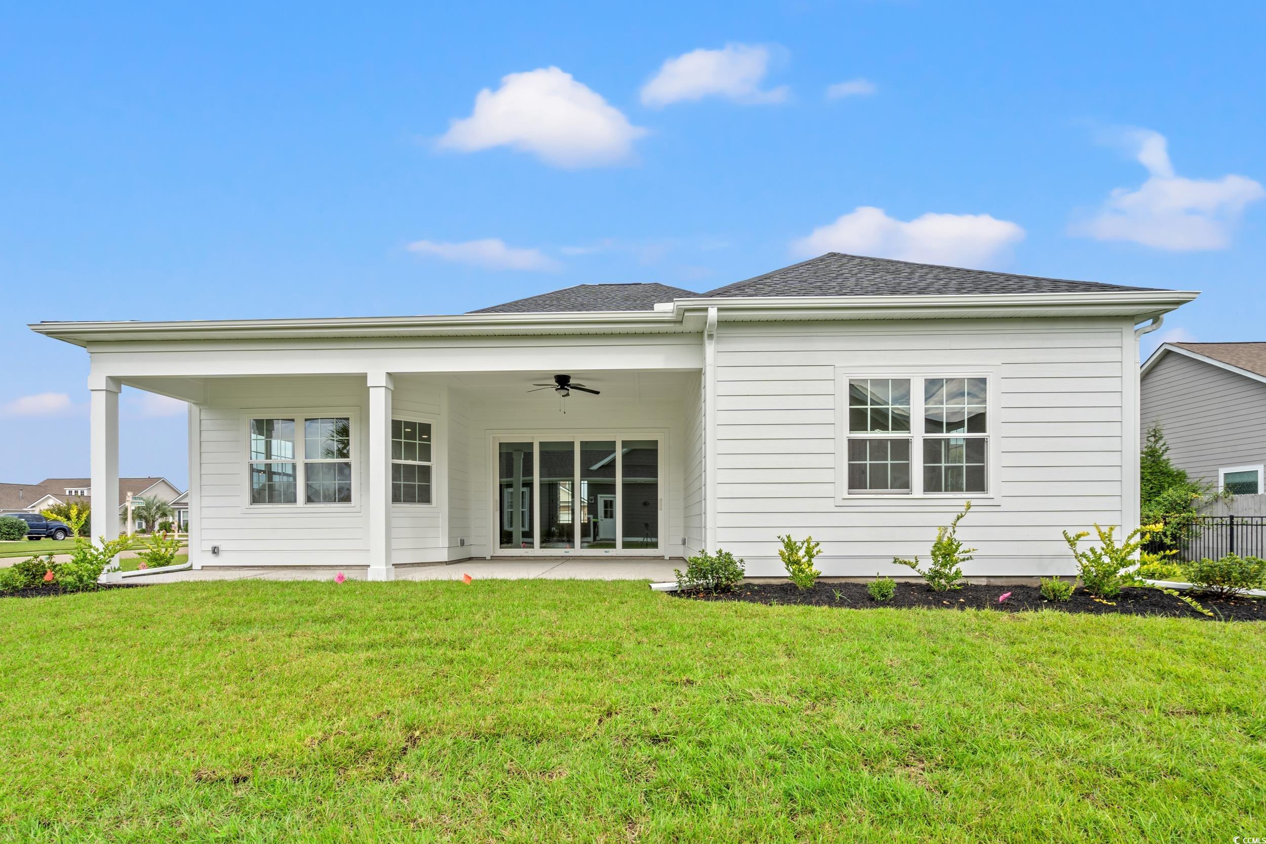 1009 Englemann Oak Drive Myrtle Beach, SC 29579 - Photo 32 of 38 Rear view of house featuring a ceiling fan, a patio, a yard, and a shingled roof