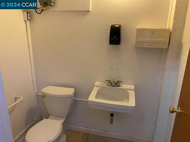 a bathroom with a toilet sink and mirror