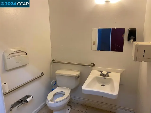 a bathroom with a toilet sink and mirror