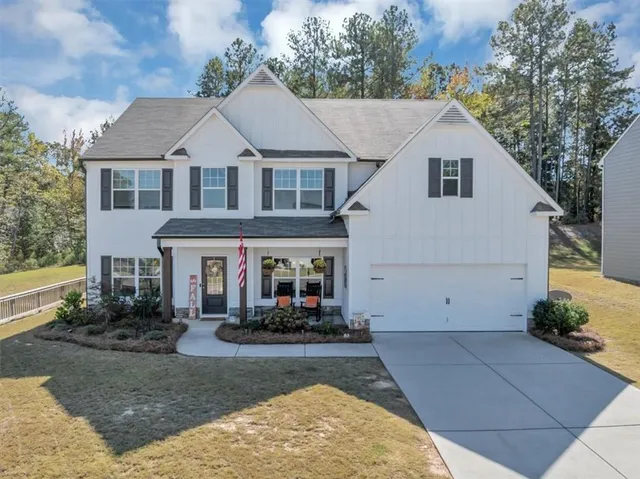 a view of a white house with large windows and a small yard