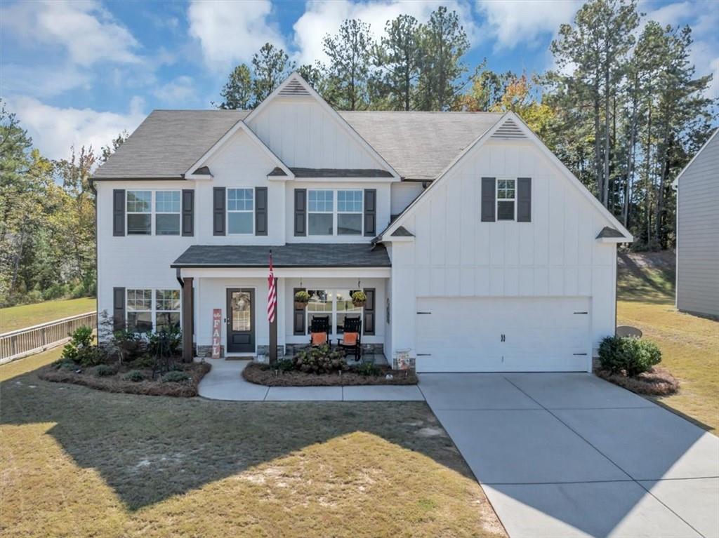 a view of a white house with large windows and a small yard