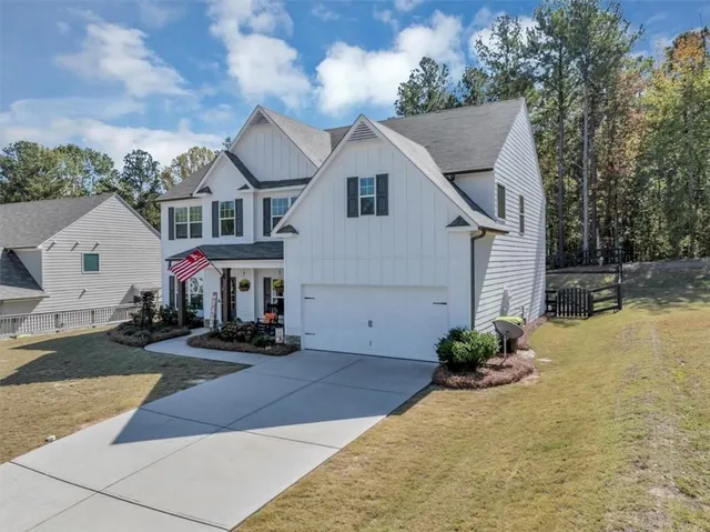 a view of a white house with wooden walls and potted plants