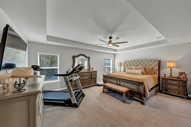 a bedroom with a large bed and a chandelier