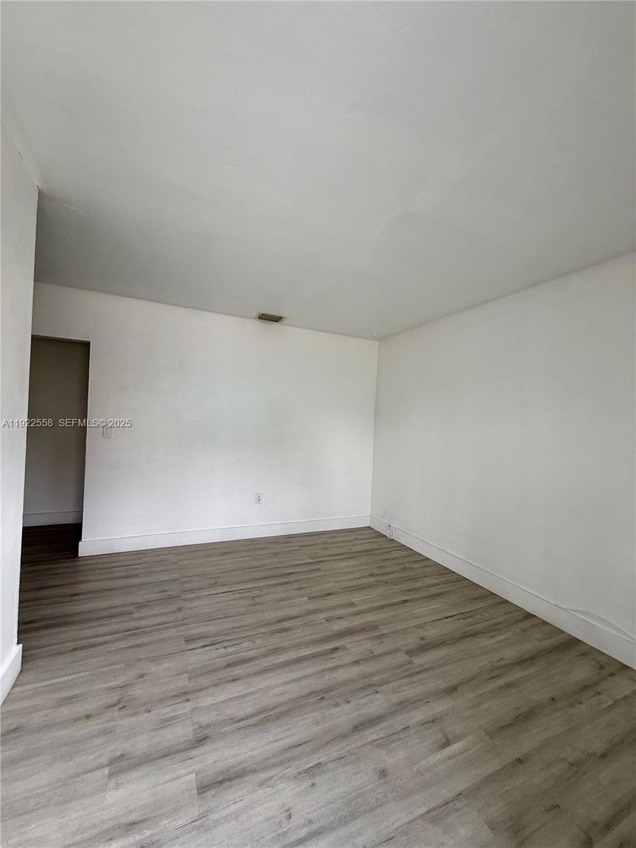 5700 Southwest 4th Street, Unit 2 Miami, FL 33144 - Photo 2 of 9 a view of an empty room with wooden floor and a window