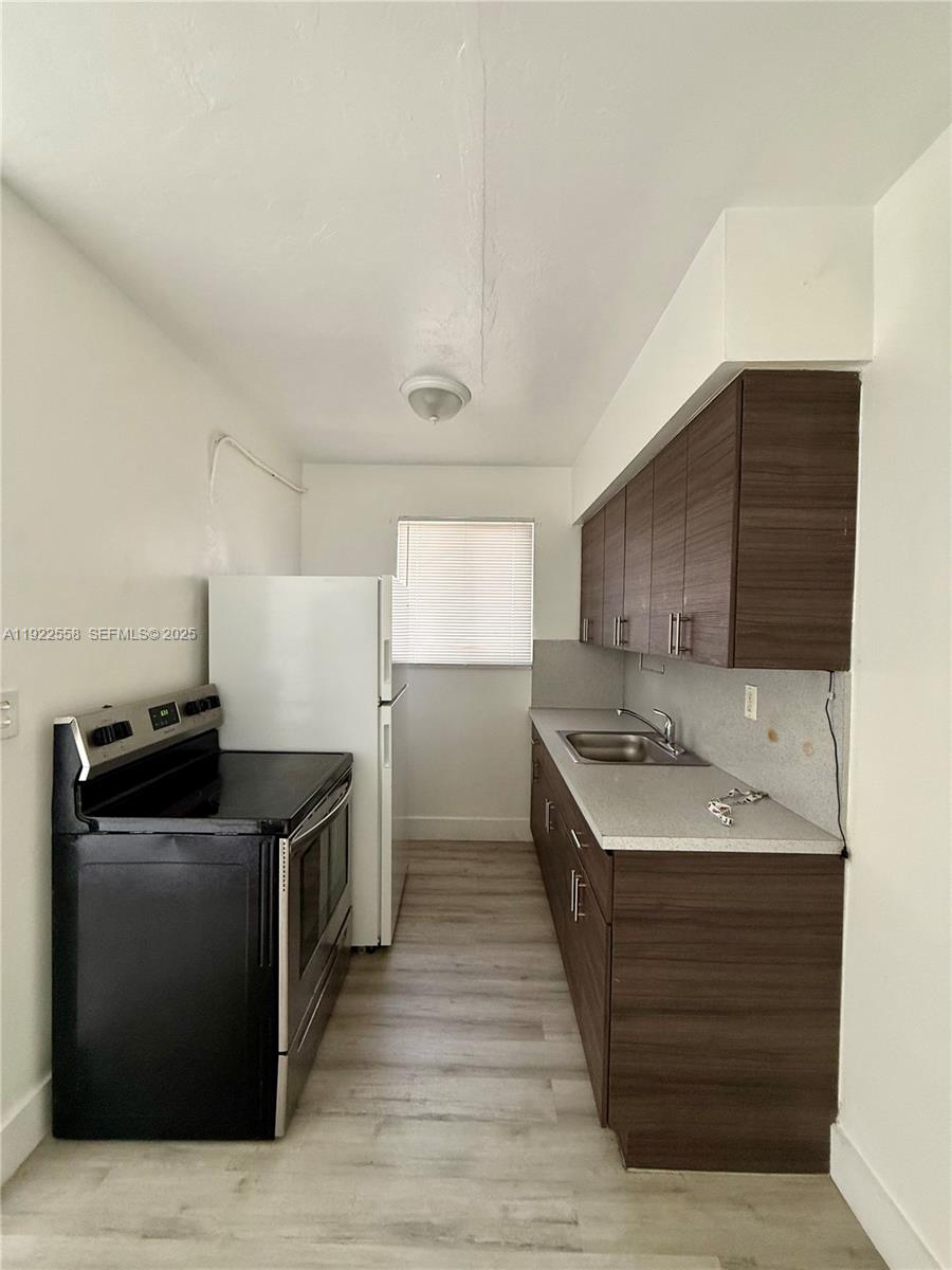 5700 Southwest 4th Street, Unit 2 Miami, FL 33144 - Photo 5 of 9 a kitchen with a sink stove and refrigerator