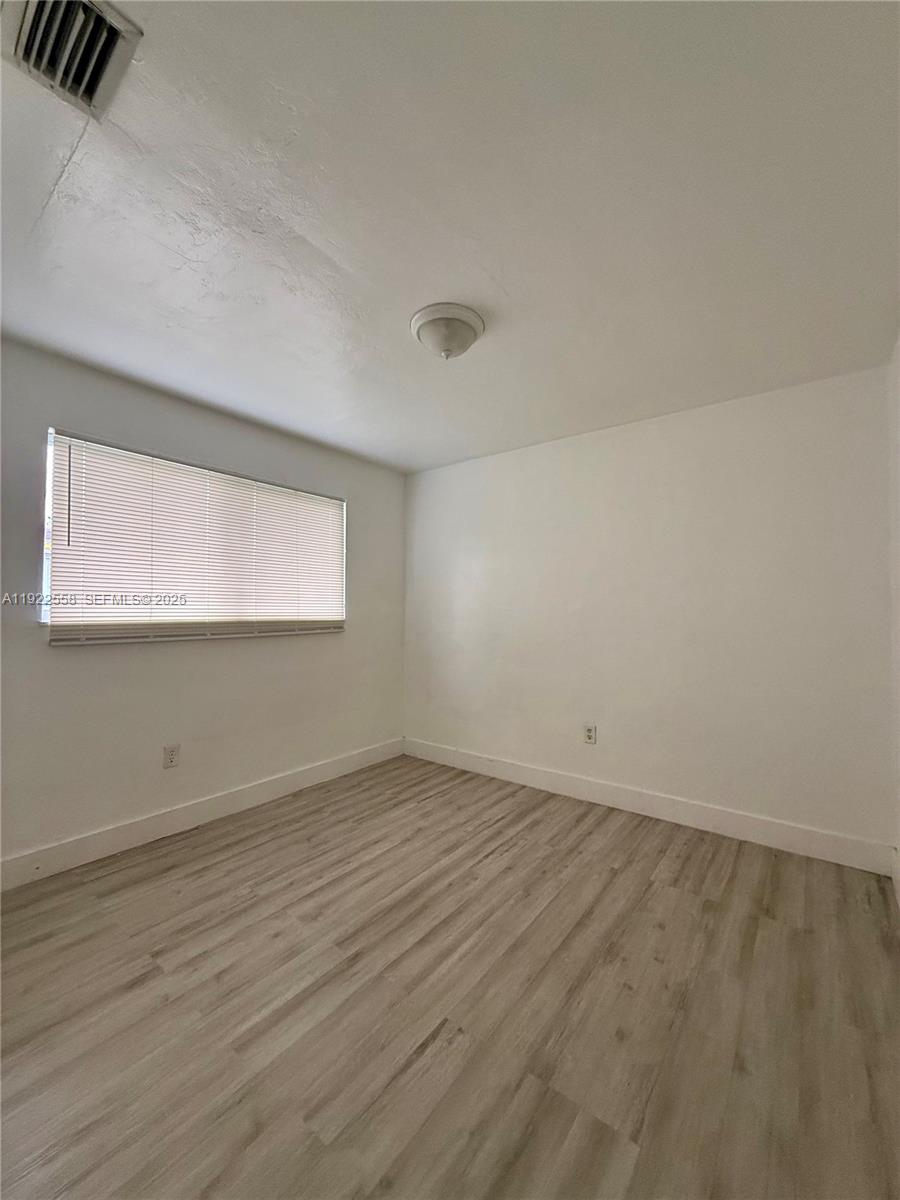 5700 Southwest 4th Street, Unit 2 Miami, FL 33144 - Photo 6 of 9 an empty room with wooden floor and windows