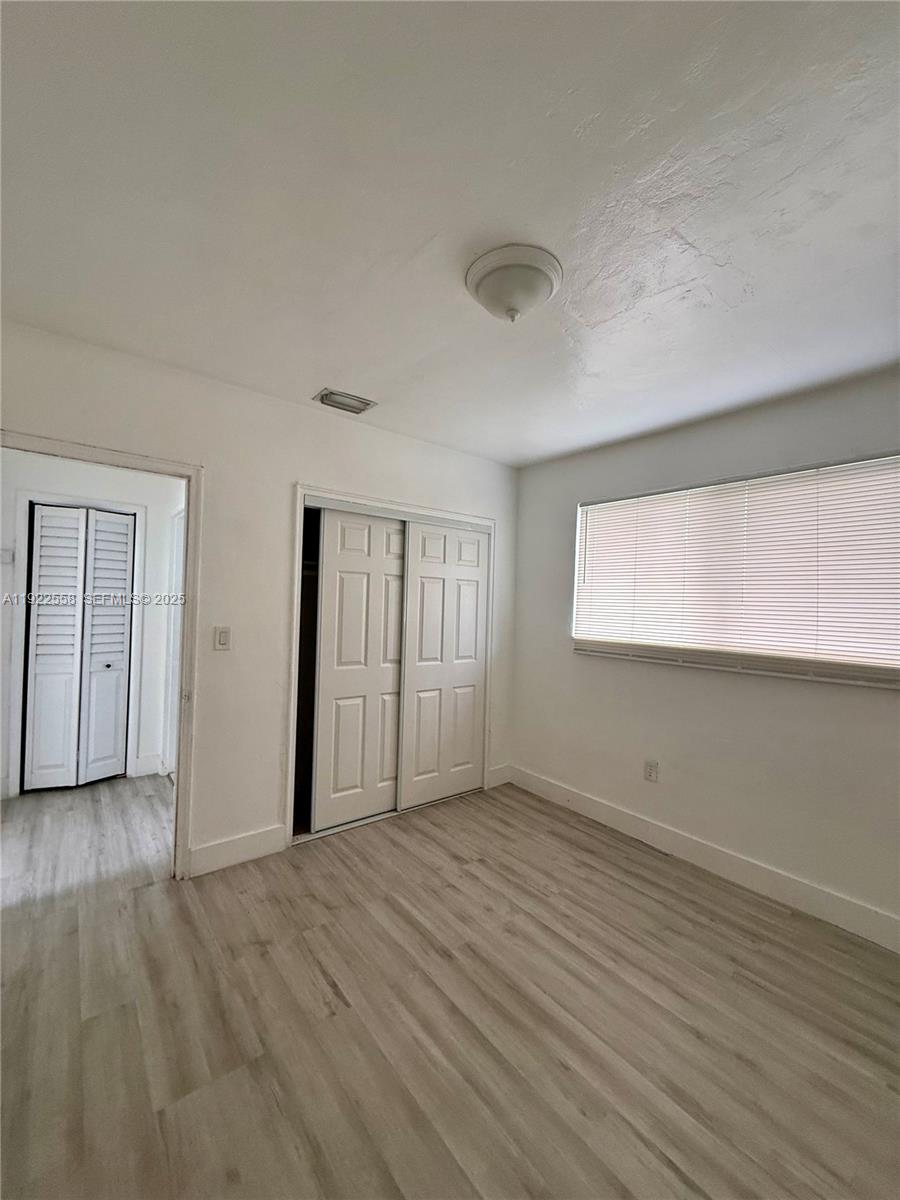 5700 Southwest 4th Street, Unit 2 Miami, FL 33144 - Photo 7 of 9 an empty room with wooden floor and windows