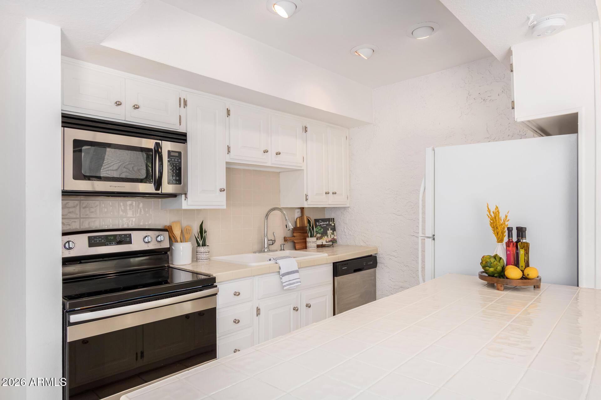 4656 North 40th Street Phoenix, AZ 85018 - Photo 12 of 28 a kitchen with stainless steel appliances a stove a sink and a refrigerator