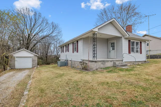 a view of a house with a yard and fence