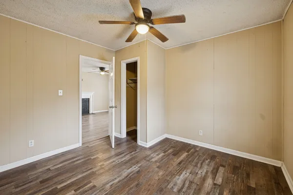 a view of a livingroom with wooden floor and a ceiling fan