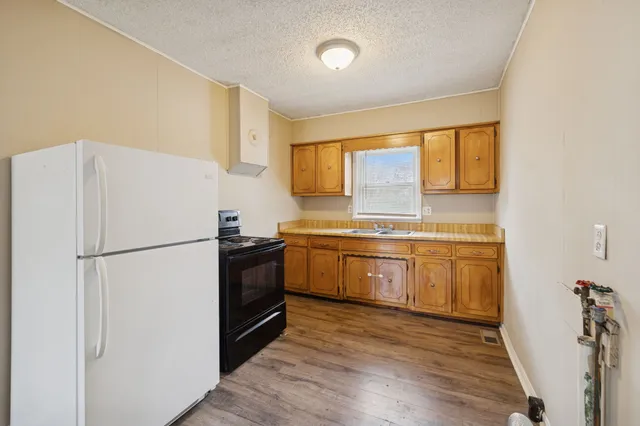 a kitchen with a refrigerator sink and cabinets