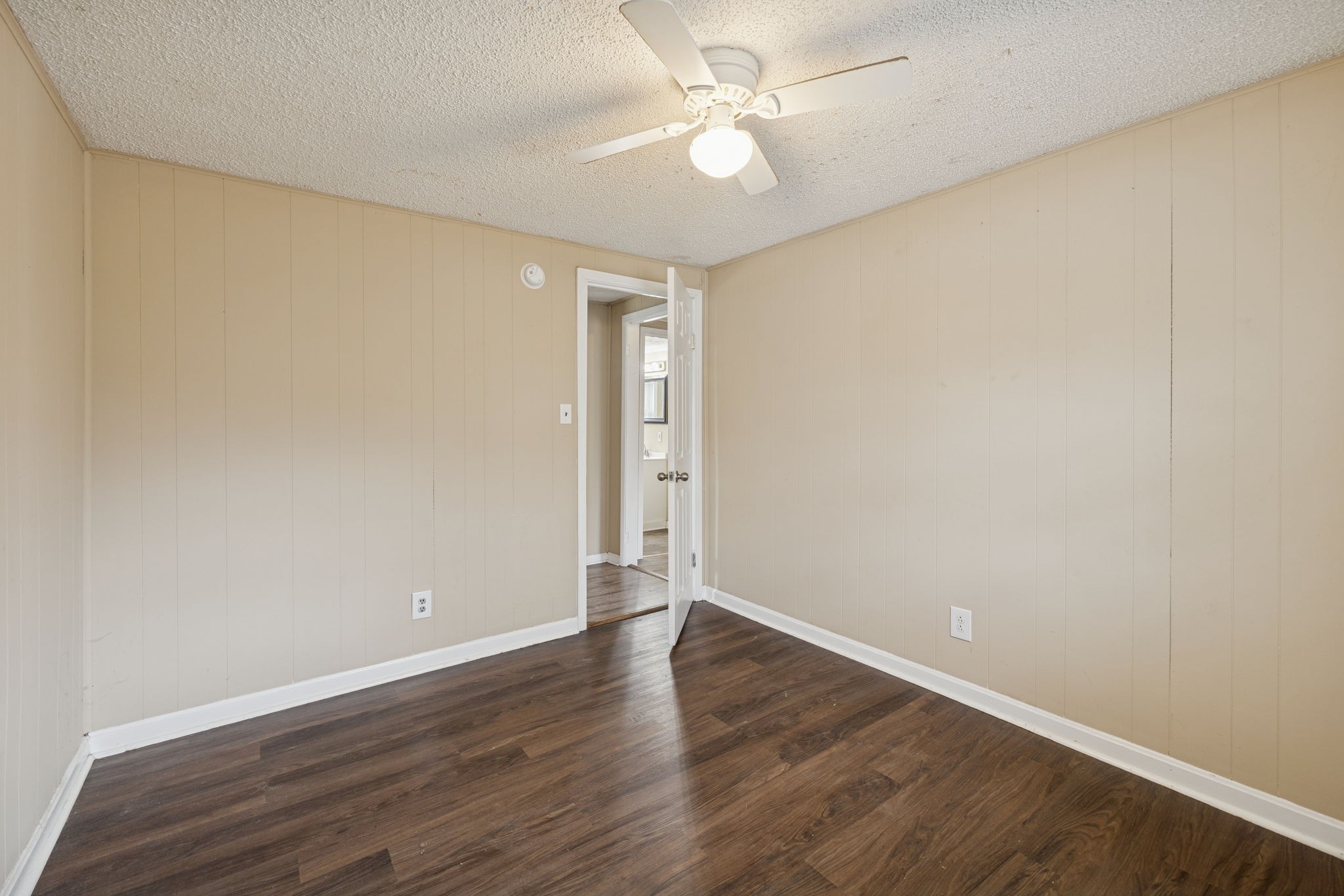 1323 Pleasant Grove Road Westmoreland, TN 37186 - Photo 19 of 26 an empty room with wooden floor and fan