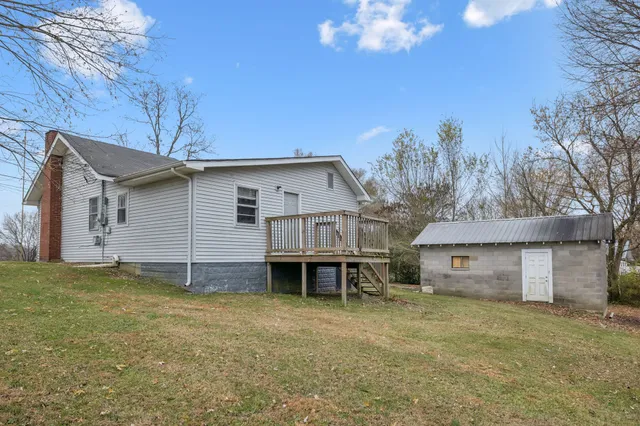 a view of a house with a backyard and a tree