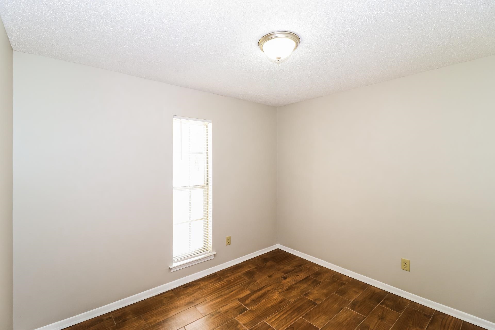 2145 Bobolink Trail Memphis, TN 38134 - Photo 11 of 16 a view of an empty room with wooden floor and a window