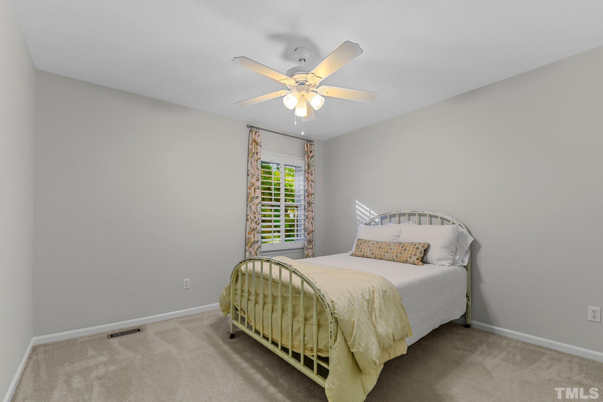 1502 Edgeside Court Raleigh, NC 27609 - Photo 14 of 27 Bedroom 2 on the 2nd Floor with ceiling fan, single window, and folding closet doors.