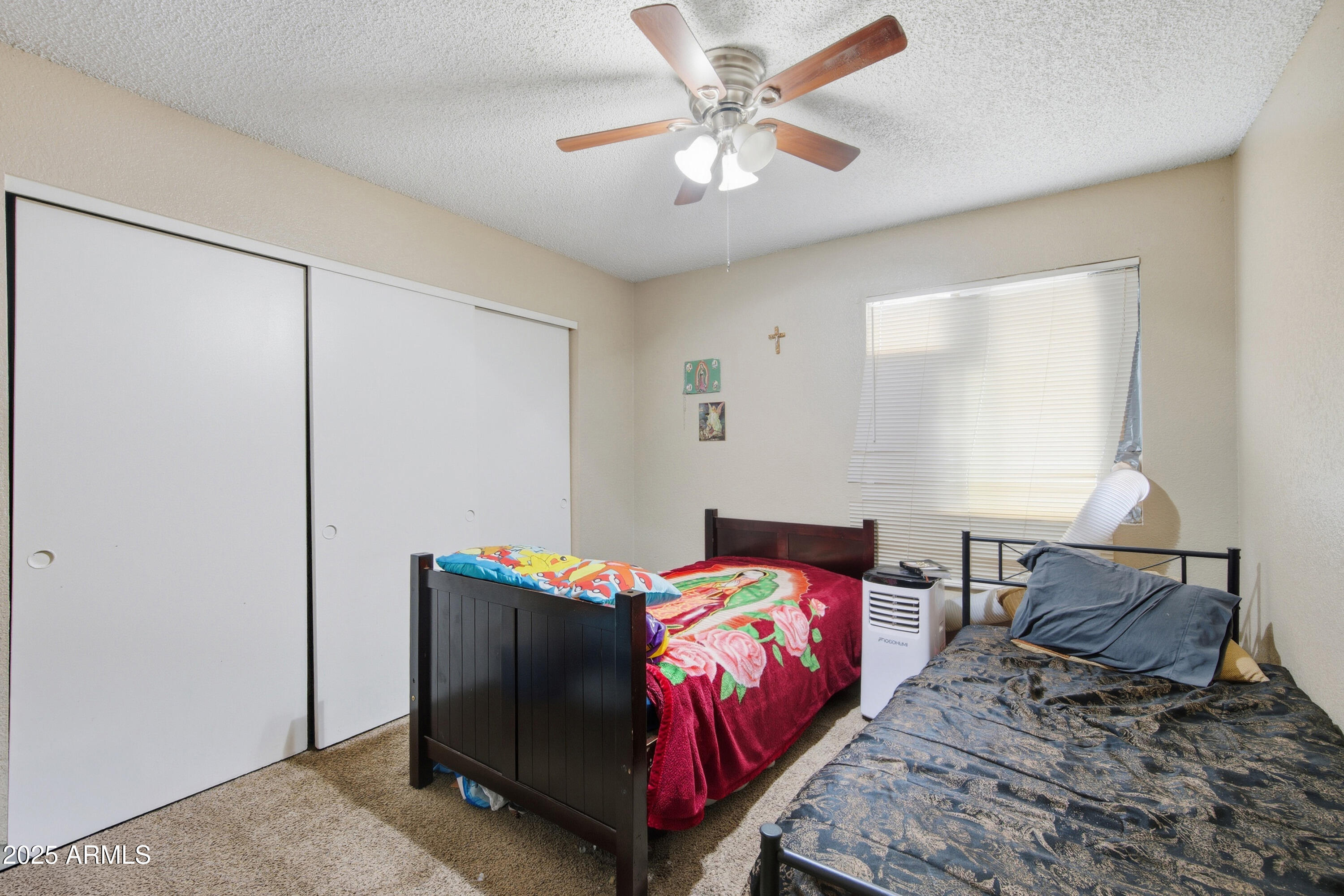 4242 North 69th Lane, Unit 1333 Phoenix, AZ 85033 - Photo 11 of 18 a bedroom with a bed and a chandelier