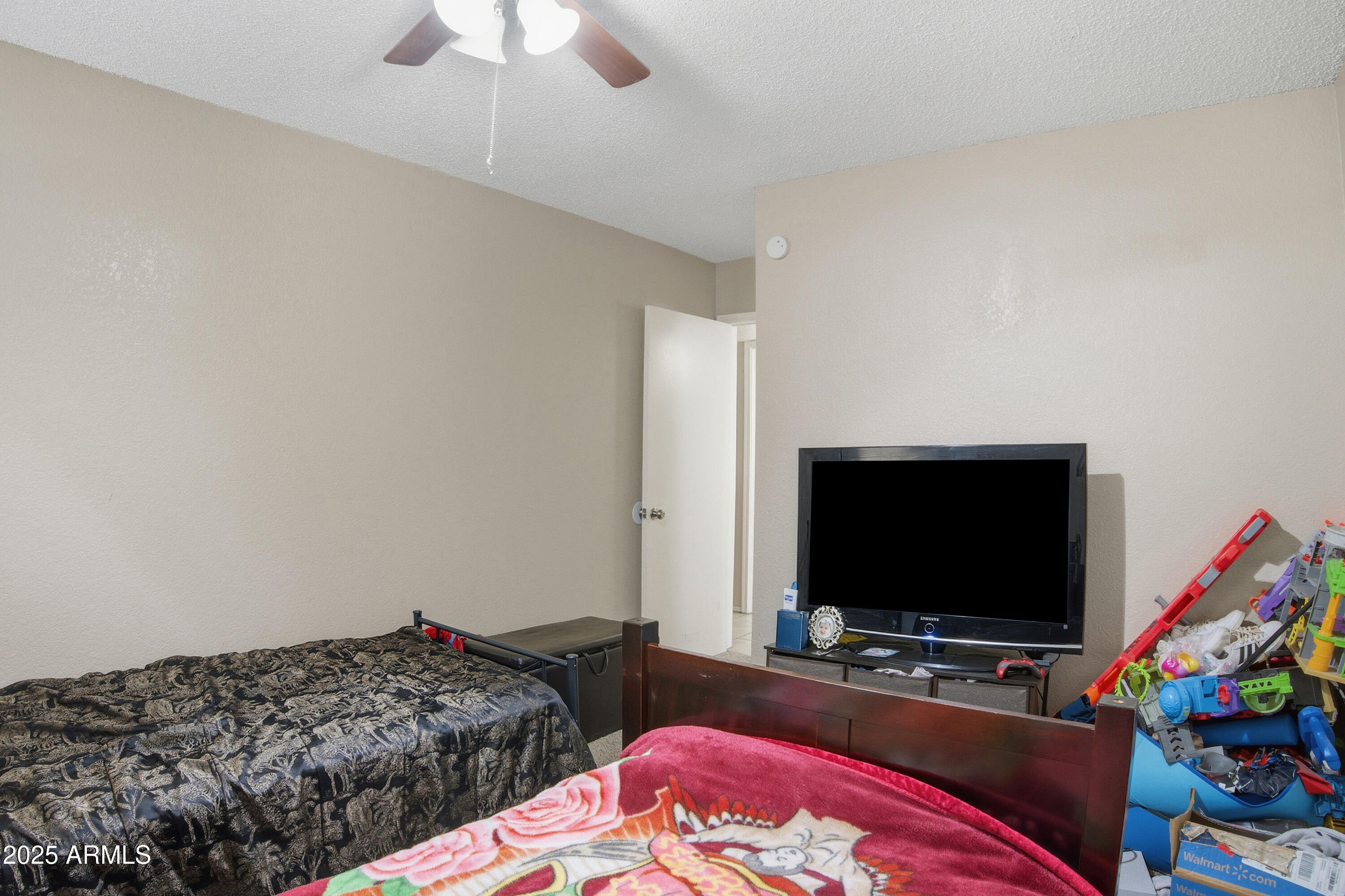4242 North 69th Lane, Unit 1333 Phoenix, AZ 85033 - Photo 12 of 18 a bedroom with bed and a flat screen tv