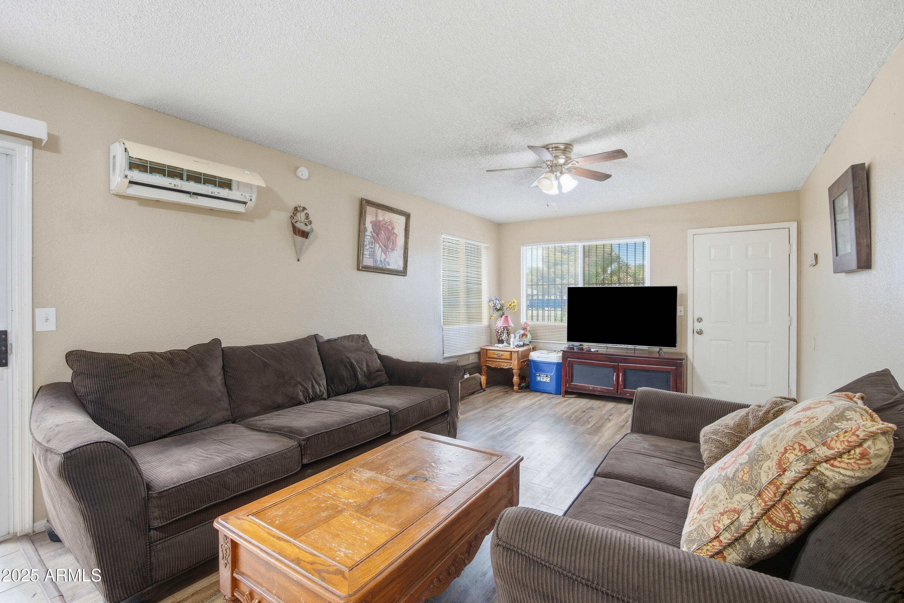 4242 North 69th Lane, Unit 1333 Phoenix, AZ 85033 - Photo 3 of 18 a living room with furniture and a flat screen tv