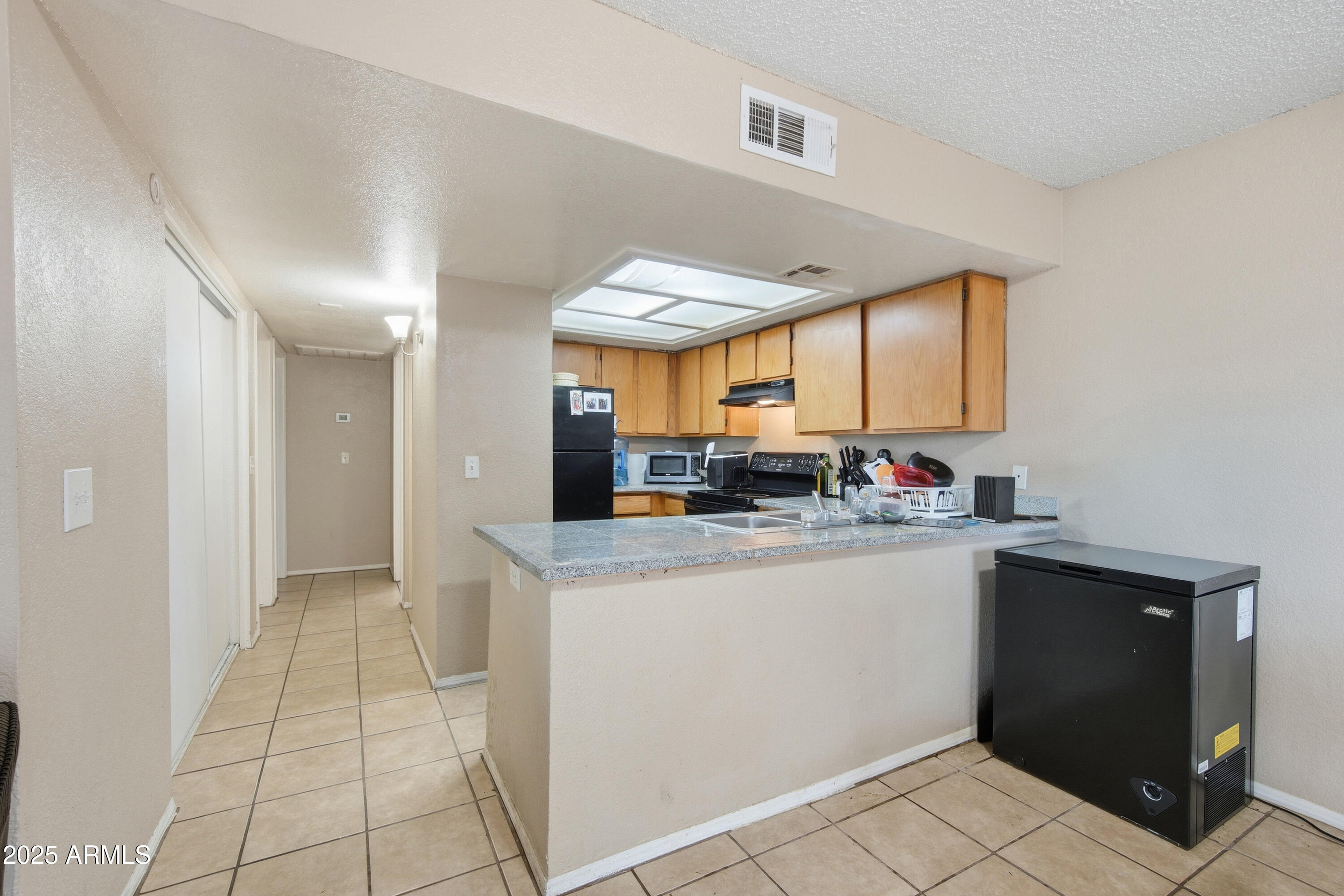 4242 North 69th Lane, Unit 1333 Phoenix, AZ 85033 - Photo 7 of 18 a kitchen with stainless steel appliances granite countertop a sink and a stove