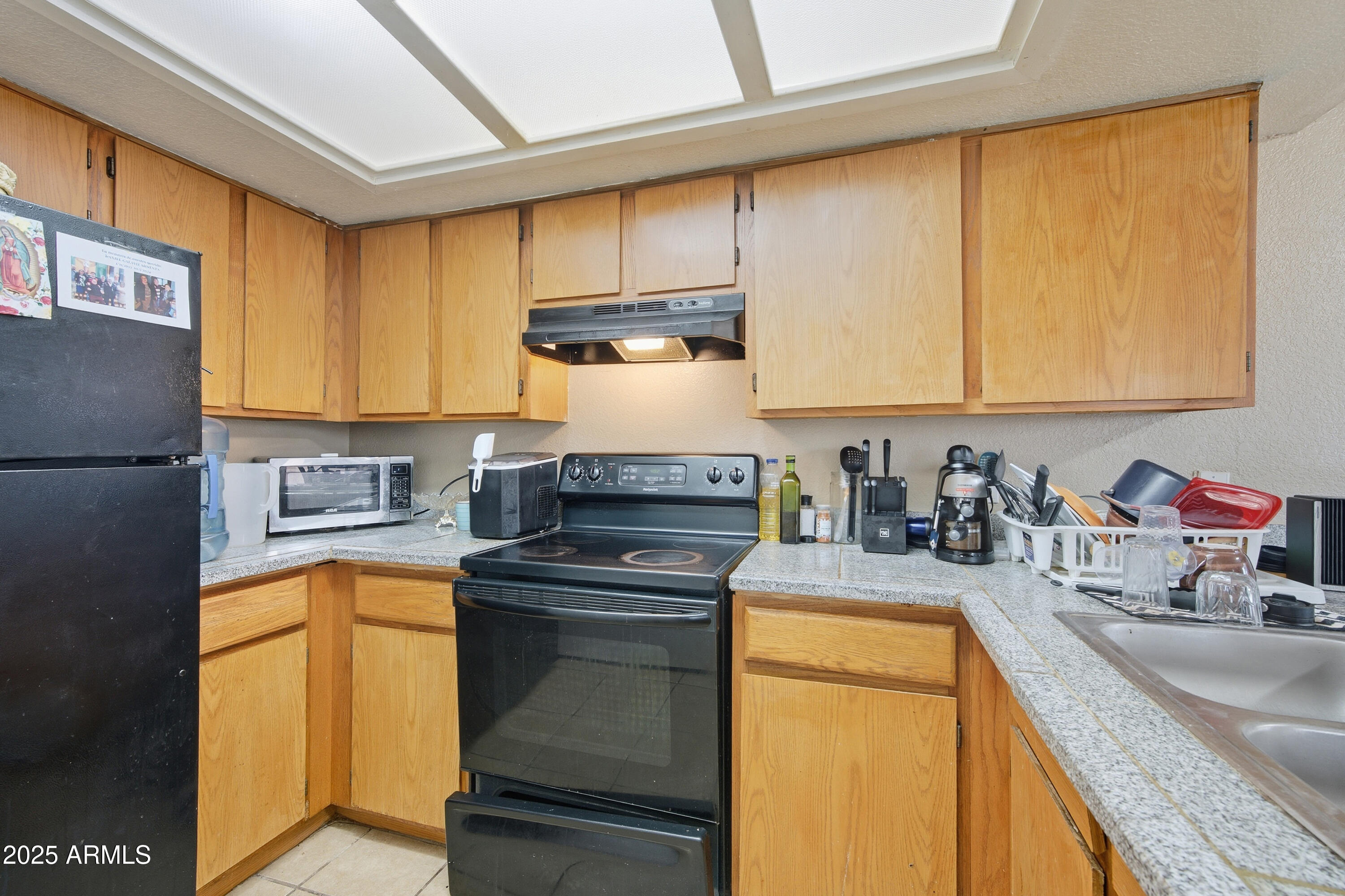 4242 North 69th Lane, Unit 1333 Phoenix, AZ 85033 - Photo 8 of 18 a kitchen with a sink a stove and cabinets