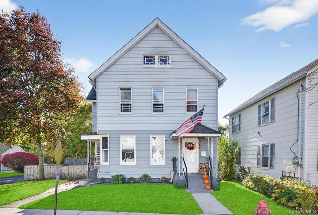 a view of a house next to a yard with big trees