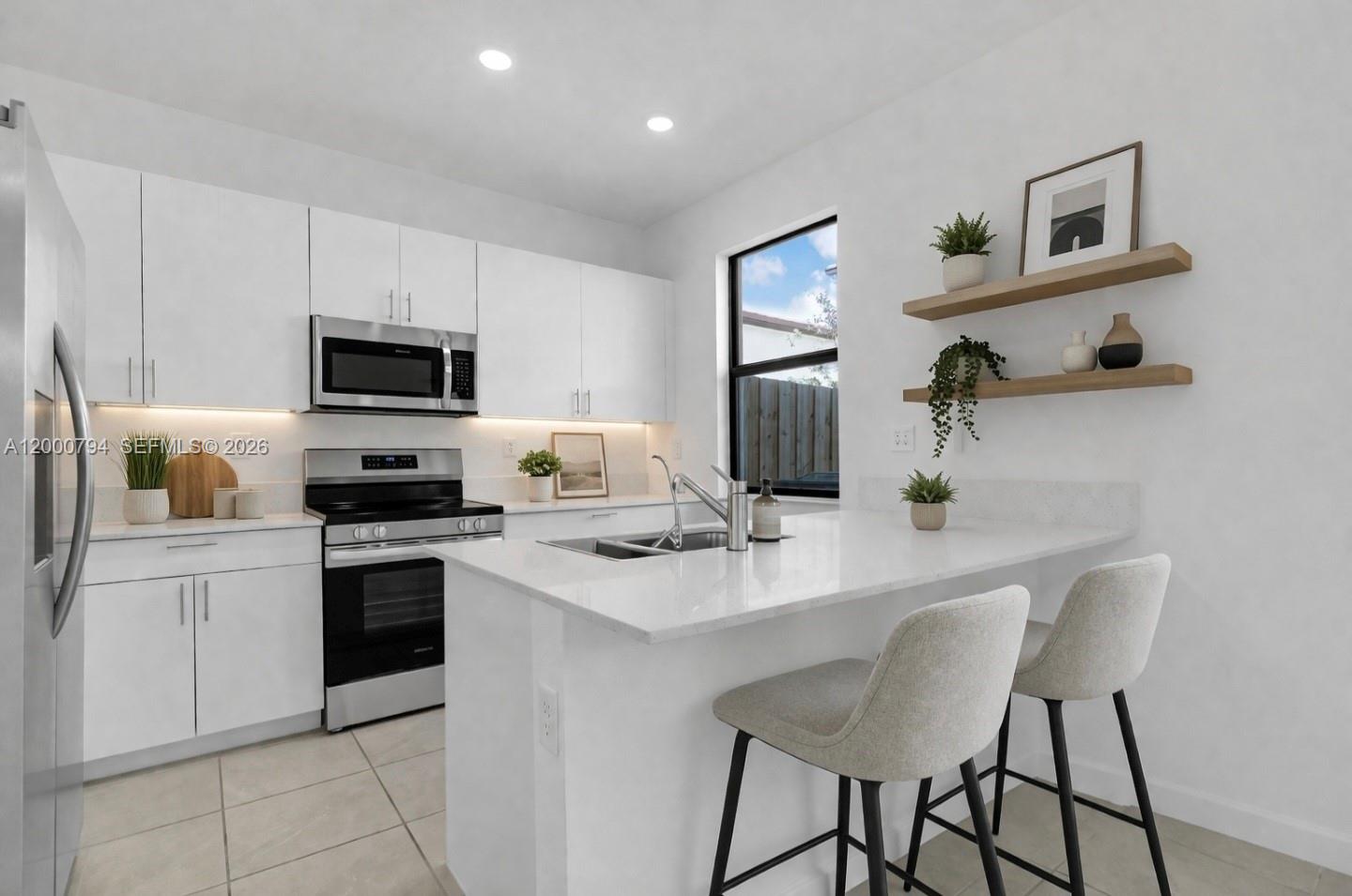 23077 Southwest 129th Place Miami, FL 33177 - Photo 11 of 43 a kitchen with a stove a sink and a refrigerator