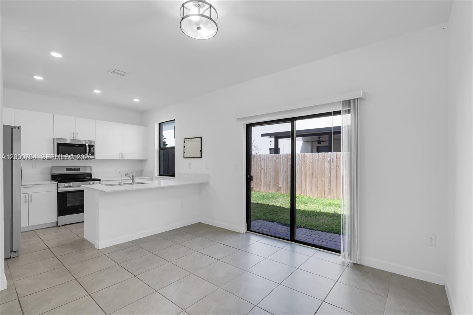 23077 Southwest 129th Place Miami, FL 33177 - Photo 15 of 43 a large white kitchen with a large window and stainless steel appliances