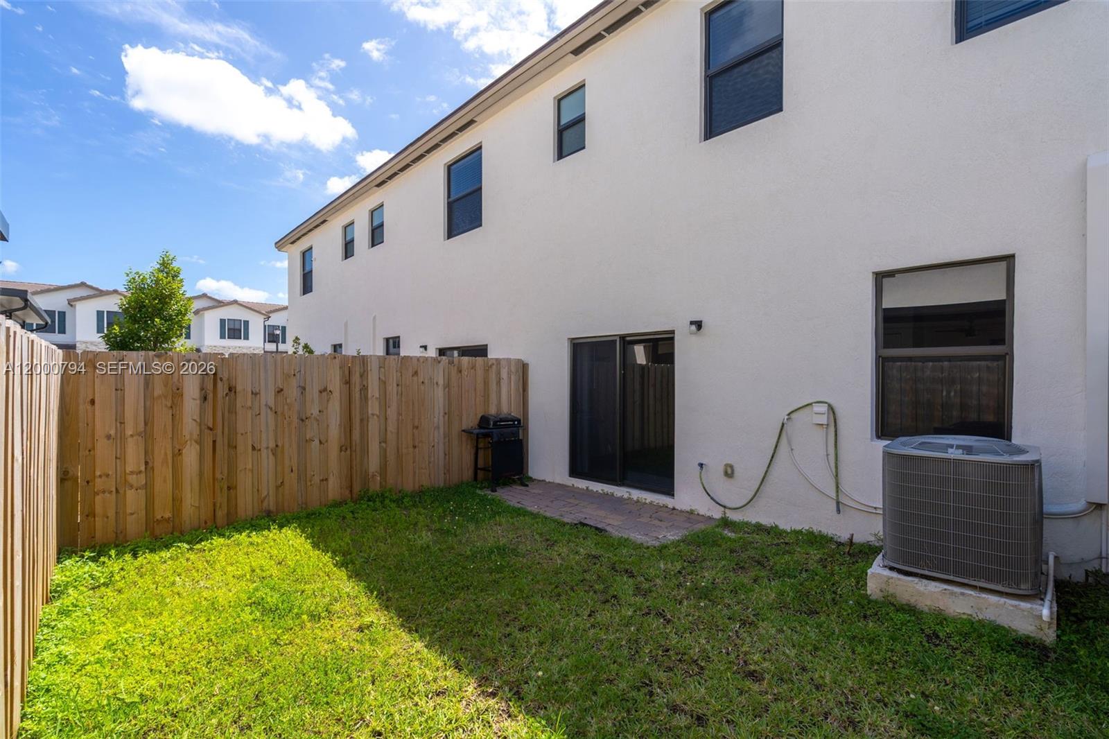 23077 Southwest 129th Place Miami, FL 33177 - Photo 17 of 43 a view of a backyard with potted plants and a wooden fence
