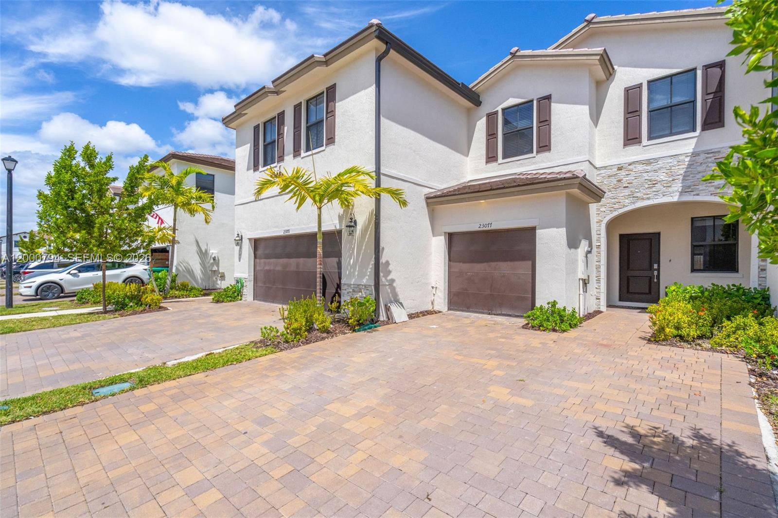 23077 Southwest 129th Place Miami, FL 33177 - Photo 5 of 43 a front view of a house with a yard and a garage
