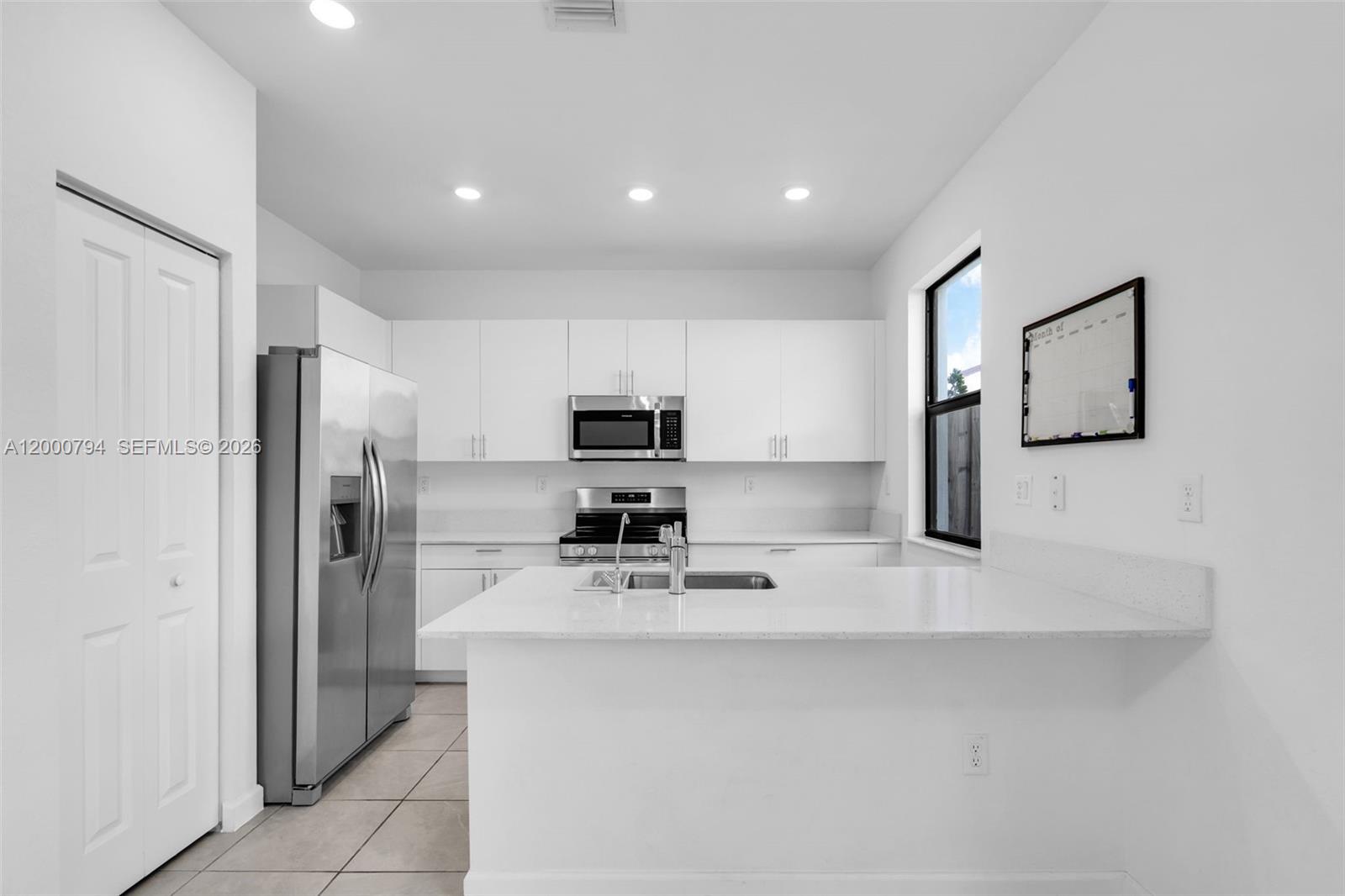 23077 Southwest 129th Place Miami, FL 33177 - Photo 9 of 43 a kitchen with stainless steel appliances a refrigerator sink and microwave