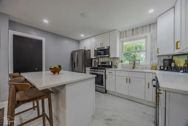 a kitchen with white cabinets and stainless steel appliances