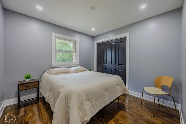 a spacious bedroom with a bed and chair