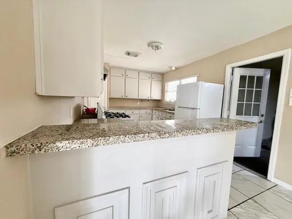 a kitchen with granite countertop a sink and a stove