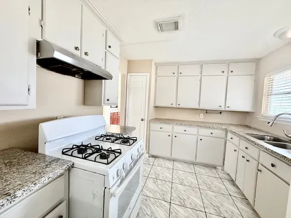 a kitchen with granite countertop cabinets and white appliances