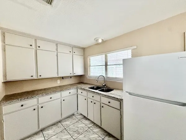 a kitchen with appliances cabinets and a window
