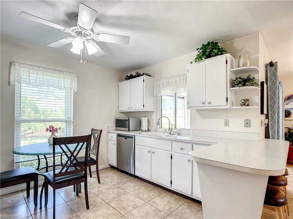 9072 Hamlin Road West Fort Myers, FL 33967 - Photo 12 of 50 a kitchen with a dining table chairs and white cabinets