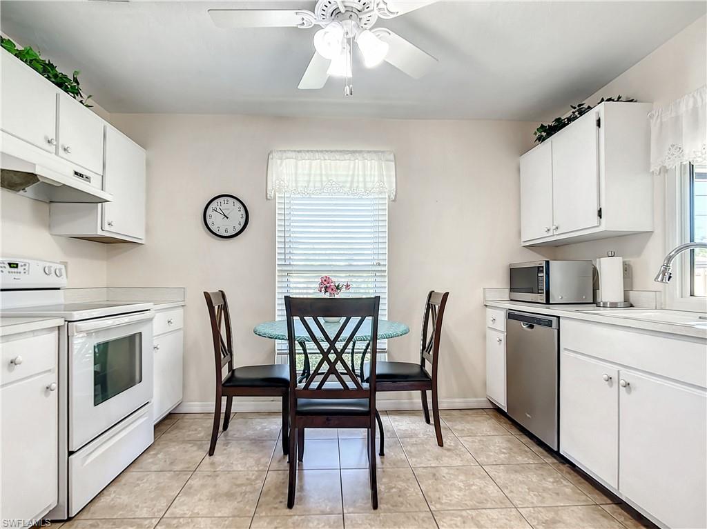 9072 Hamlin Road West Fort Myers, FL 33967 - Photo 13 of 50 a kitchen with stainless steel appliances a white table chairs and a refrigerator