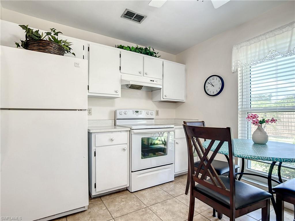 9072 Hamlin Road West Fort Myers, FL 33967 - Photo 8 of 50 a kitchen with stainless steel appliances a stove a refrigerator a dining table and chairs with wooden floor