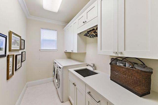 a backyard of a house with table and chairs potted plants and palm tree