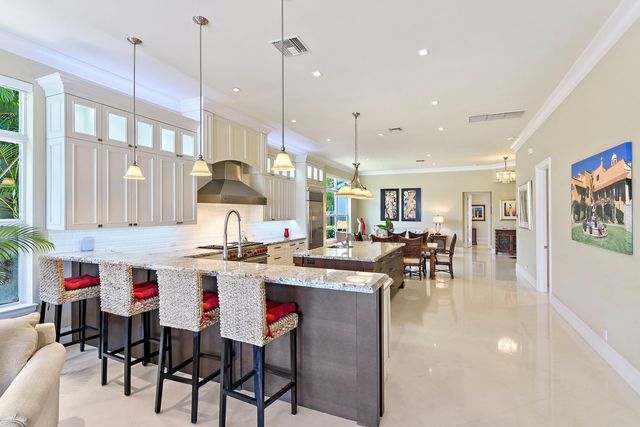 a kitchen with stainless steel appliances granite countertop table chairs and white cabinets