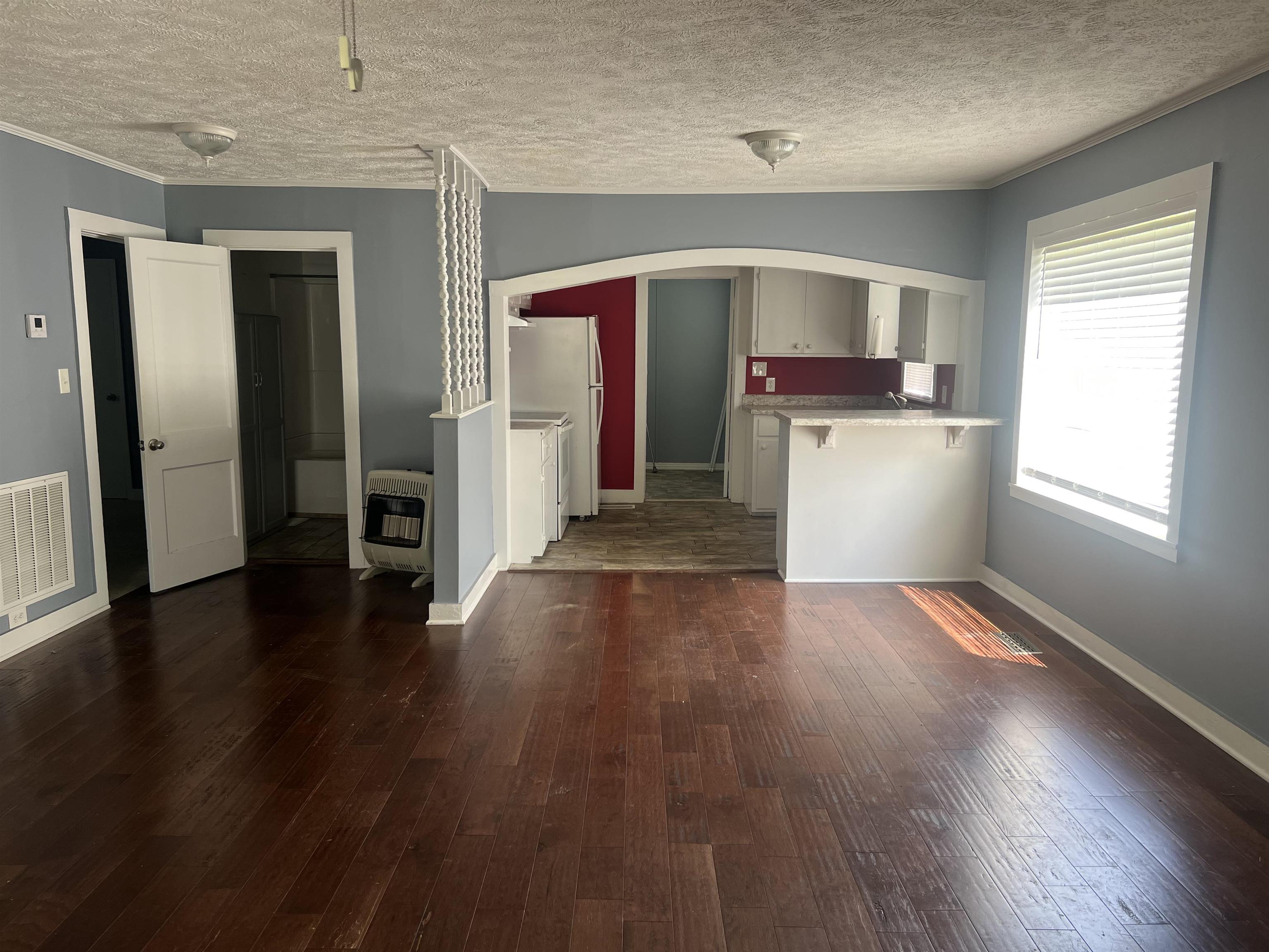 255 North Maple Street Adamsville, TN 38310 - Photo 8 of 17 Kitchen featuring a textured ceiling, dark hardwood / wood-style floors, and white fridge