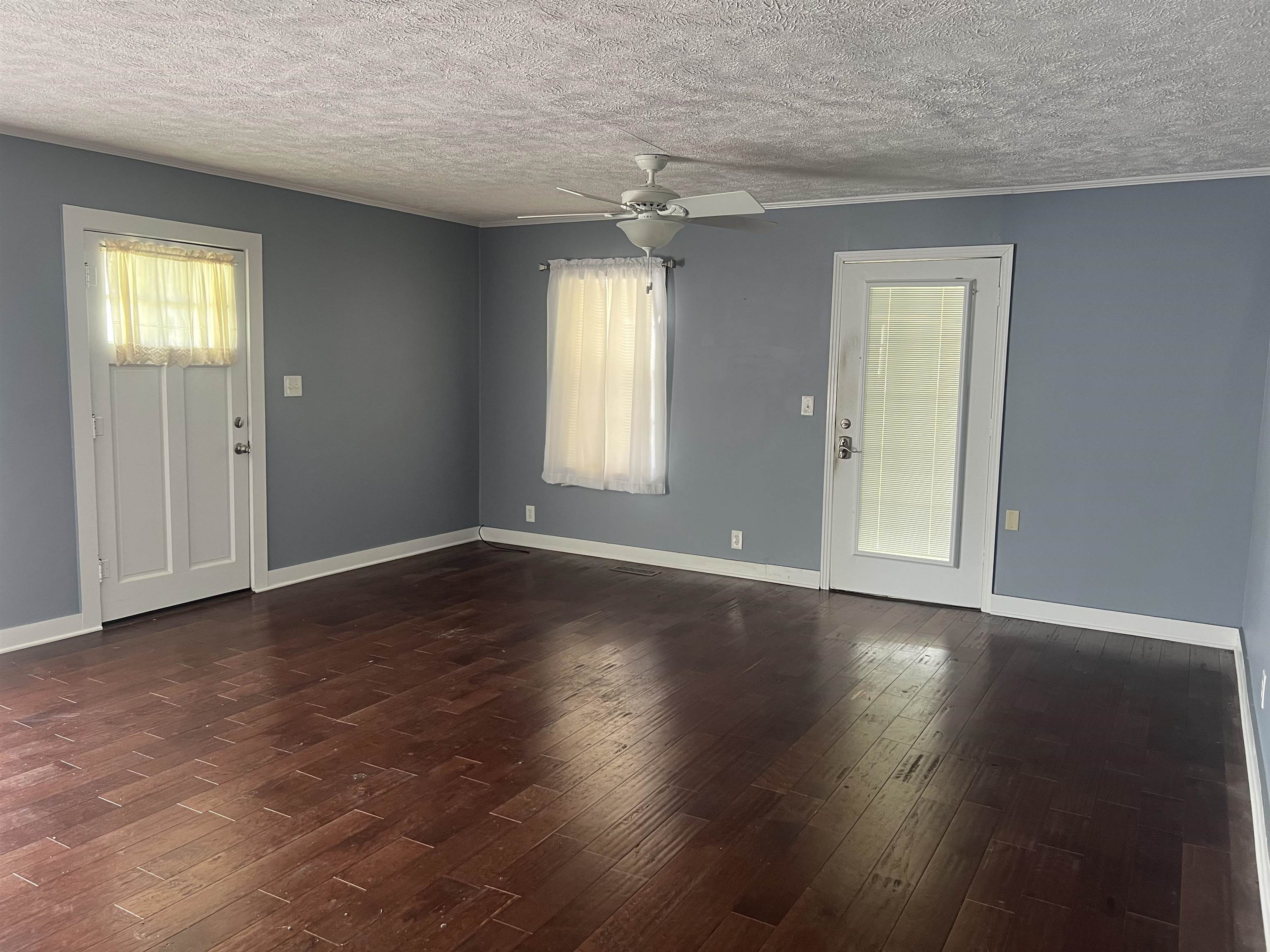255 North Maple Street Adamsville, TN 38310 - Photo 10 of 17 Spare room with ceiling fan, dark hardwood / wood-style flooring, and a textured ceiling