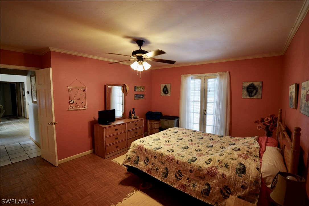 8036 Anhinga Road Fort Myers, FL 33967 - Photo 14 of 28 a bedroom with a bed and a chandelier